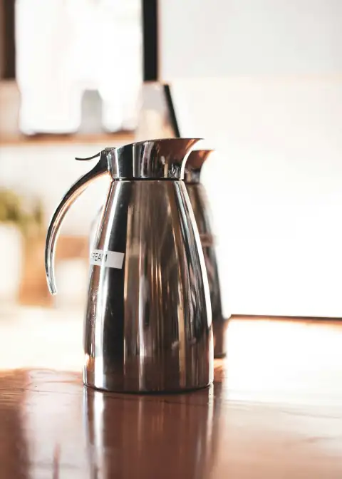 Water campers & jugs: black and silver pitcher on brown wooden table
