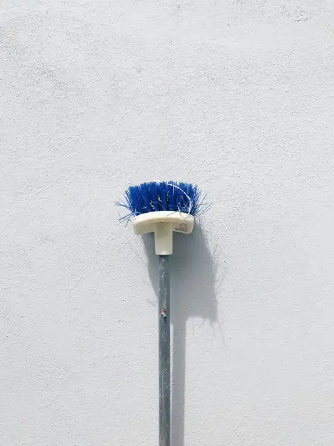Toilet & basin brushes: a white wall with a blue brush on top of it