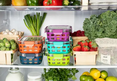 Containers & jars: Colorful plastic food containers stacked inside a refrigerator with fresh produc