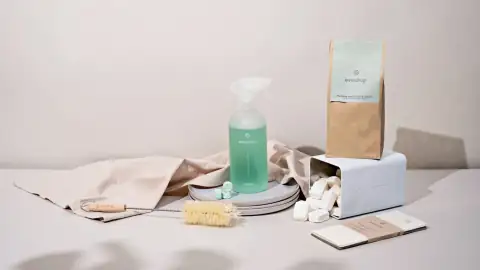 Phenyl & cleaners: a white table with a bottle of soap, a brush, and other items