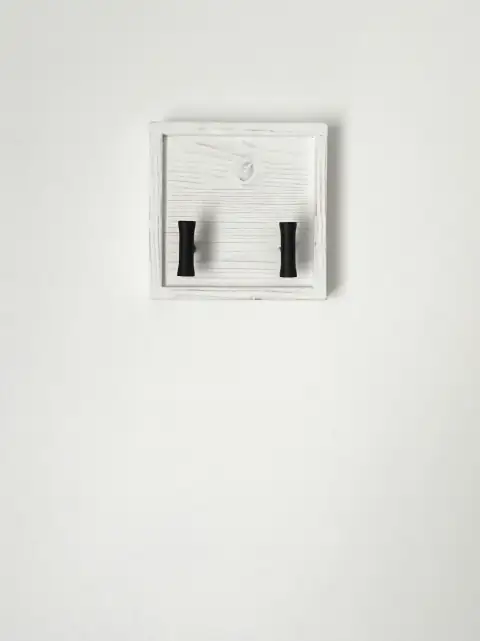 Hooks: a pair of black handles on a white wall