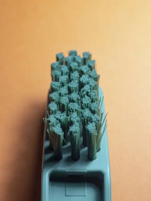 Toilet & basin brushes: Close-up of a green scrubbing brush on orange background