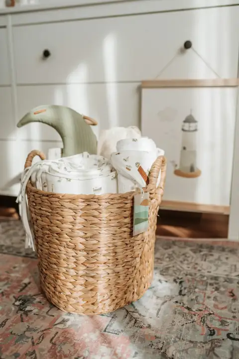 Baskets: a wicker basket filled with blankets on top of a rug
