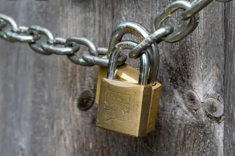 Locks: brown padlock on brown wooden fence